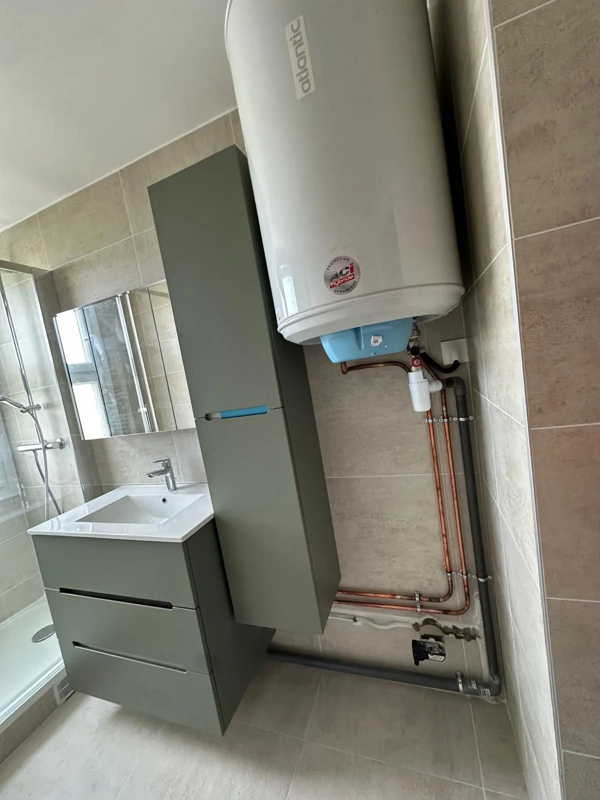 Chauffe-eau et meuble vasque dans une salle d'eau en cours