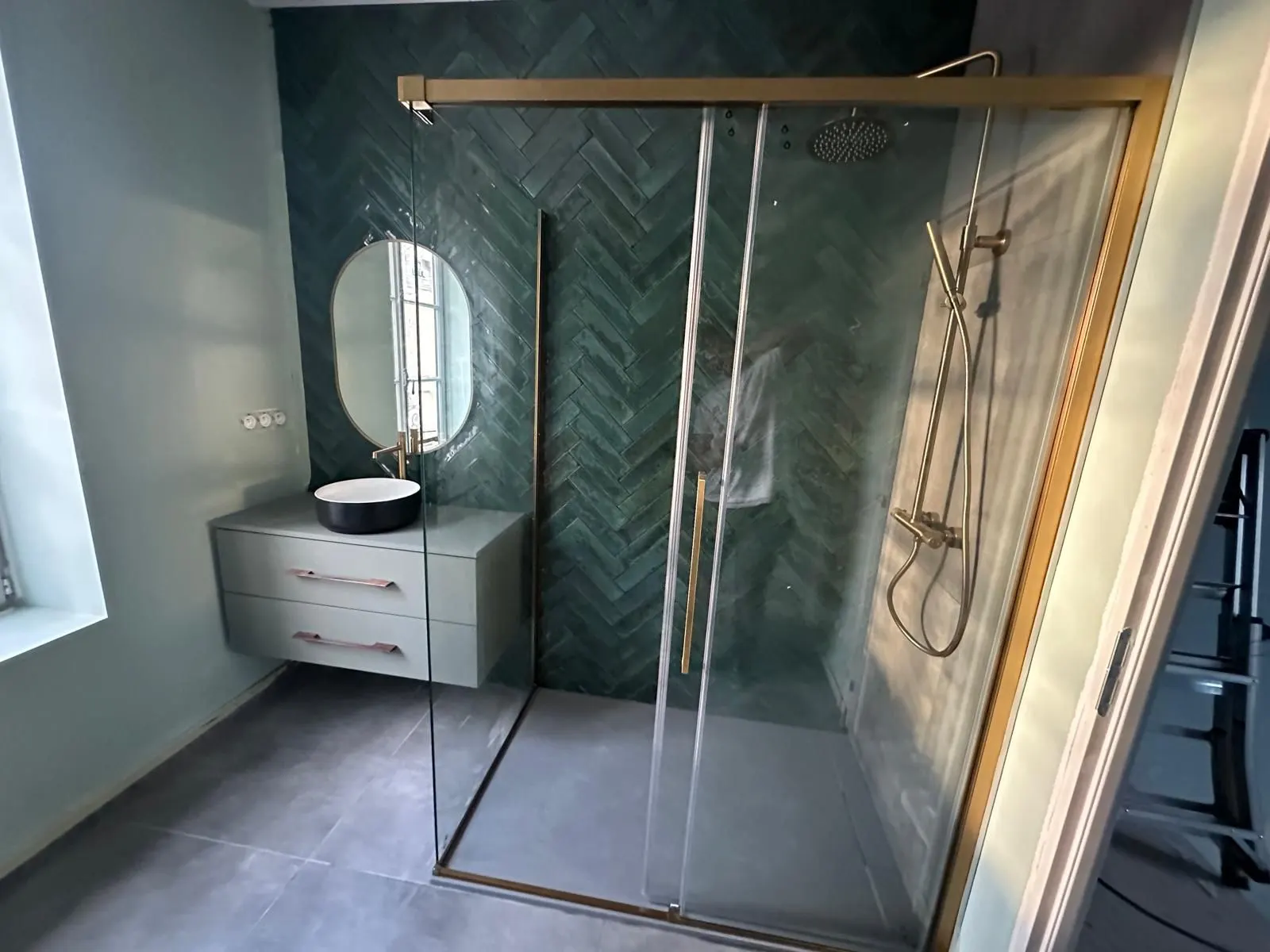 Salle d'eau, mur vert en chevron et paroi vitrée