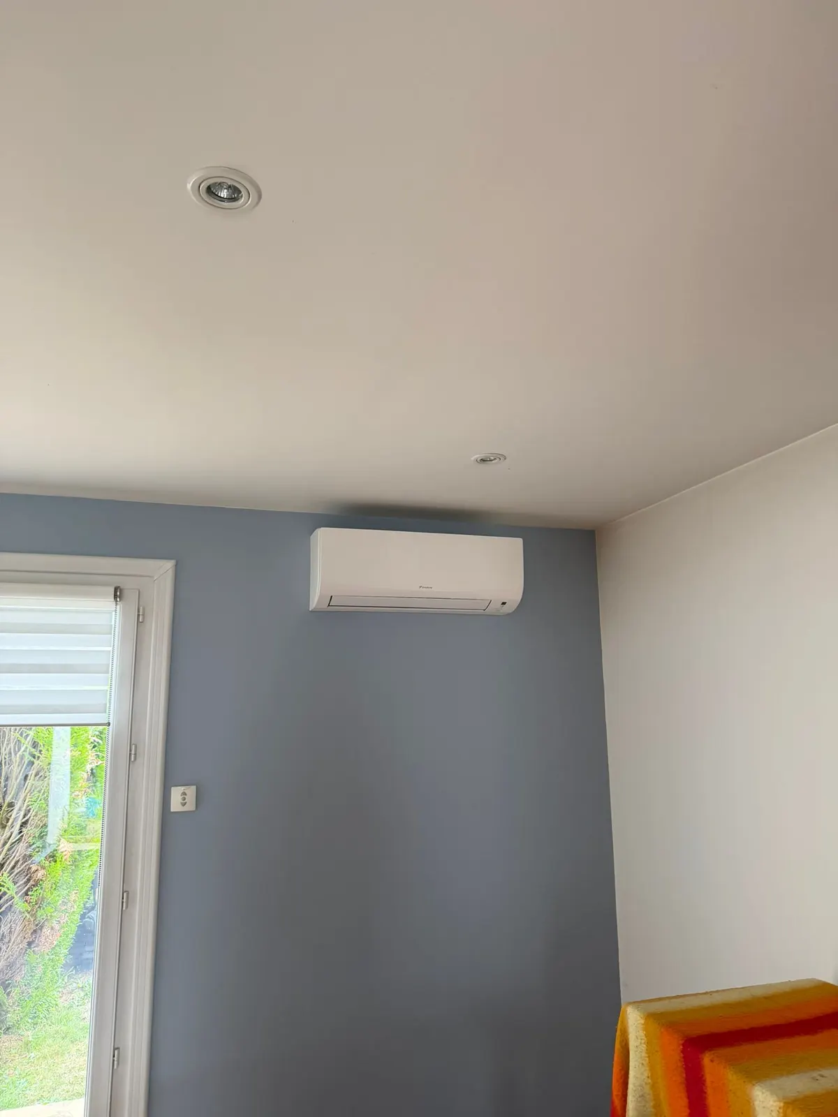 Climatiseur mural près d'une baie vitrée