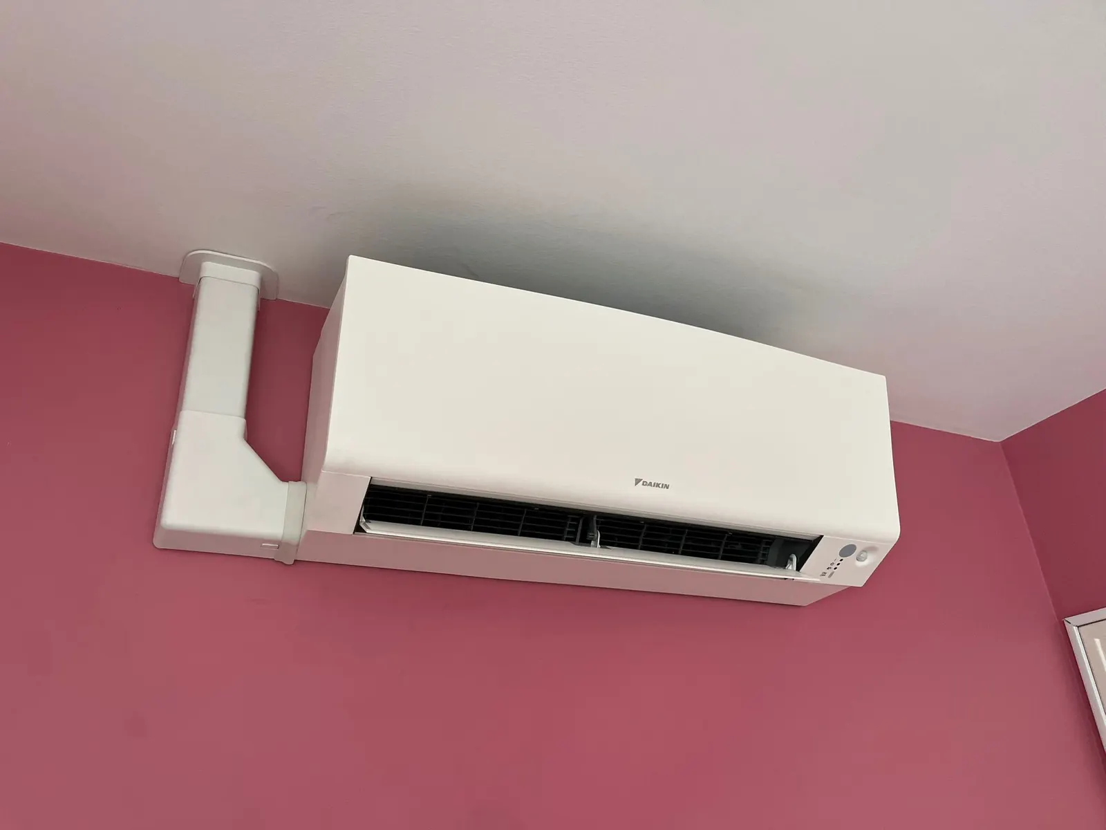 Climatiseur sur un mur framboise