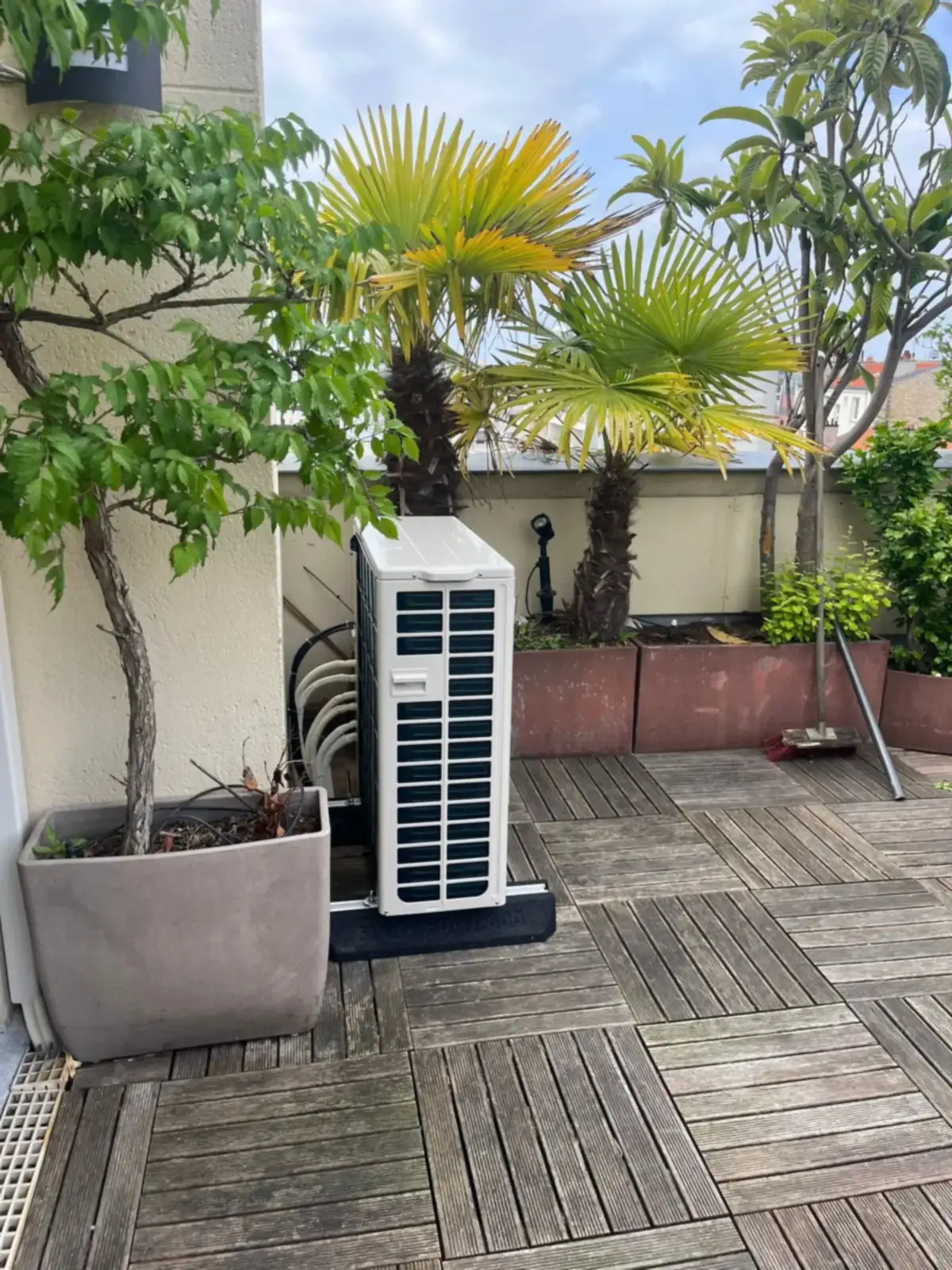 Groupe extérieur posé sur une terrasse en bois